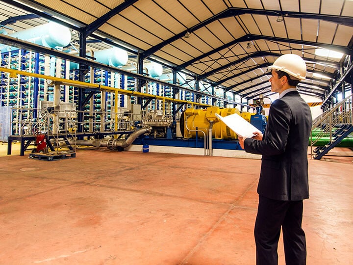 Inspector with notepad in industrial facility